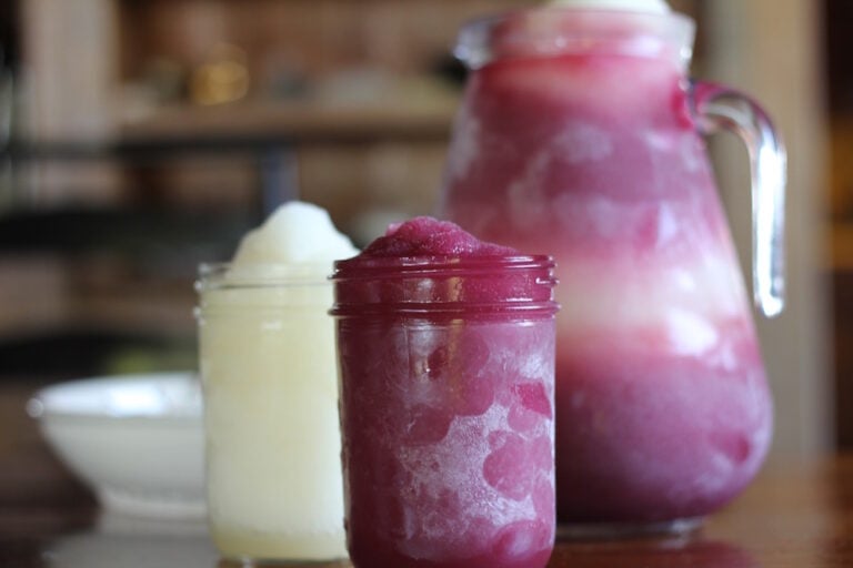 Two glasses and a pitcher of Quady Electra Moscato and Quady Red Electra Moscato wine slushies.