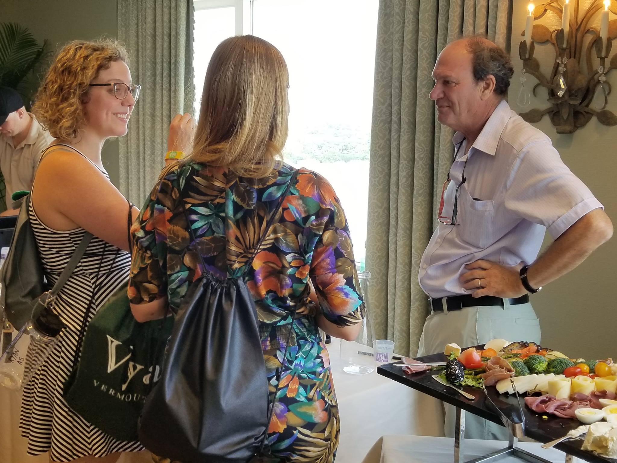 Andrew Quady talking to two young ladies at the vya vermouth tasting and seminar at tales of the cocktail.