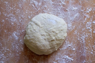 Ball of flat bread dough with flour.