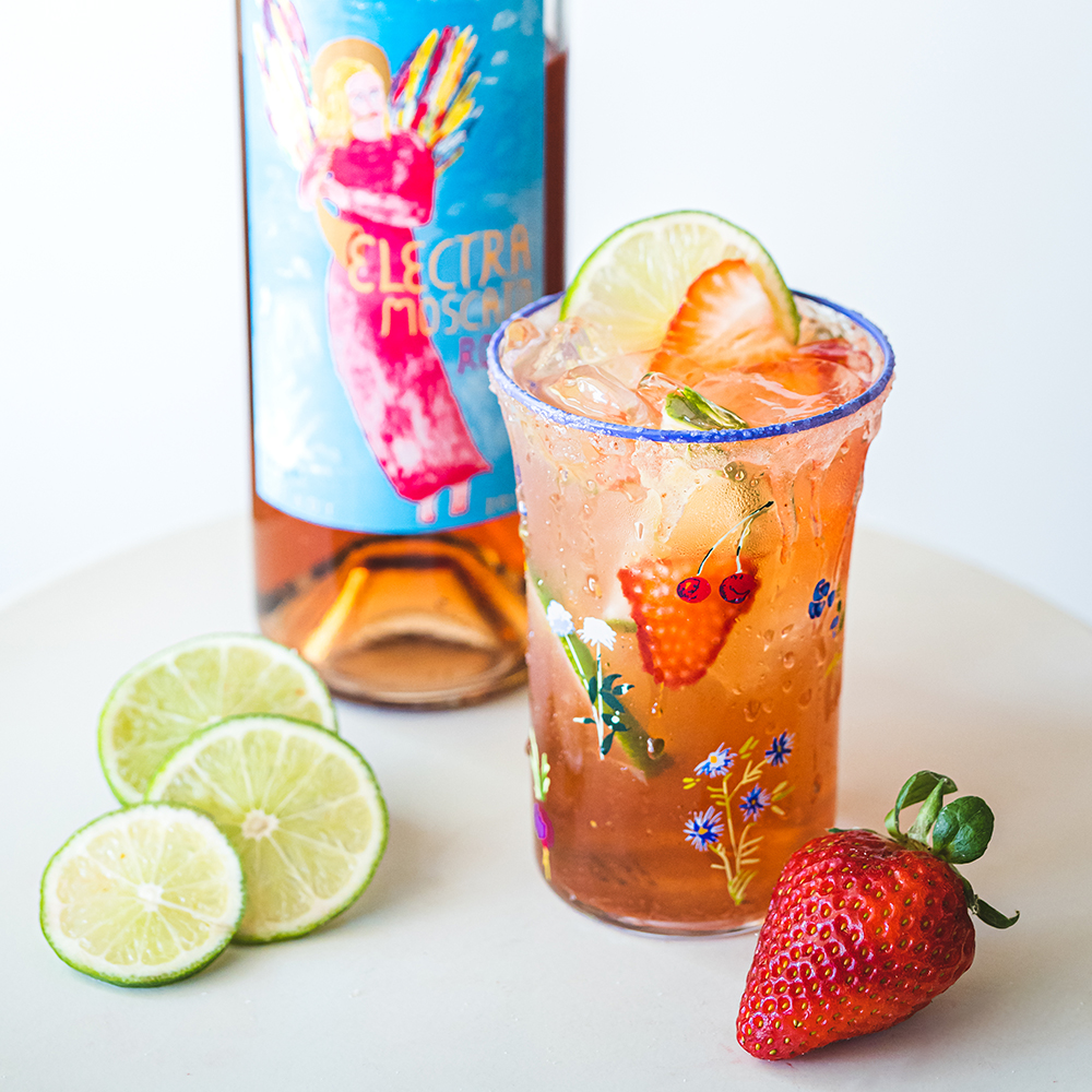 Electra Roserita Rose Margarita with a bottle of Electra Rose, limes and a strawberry