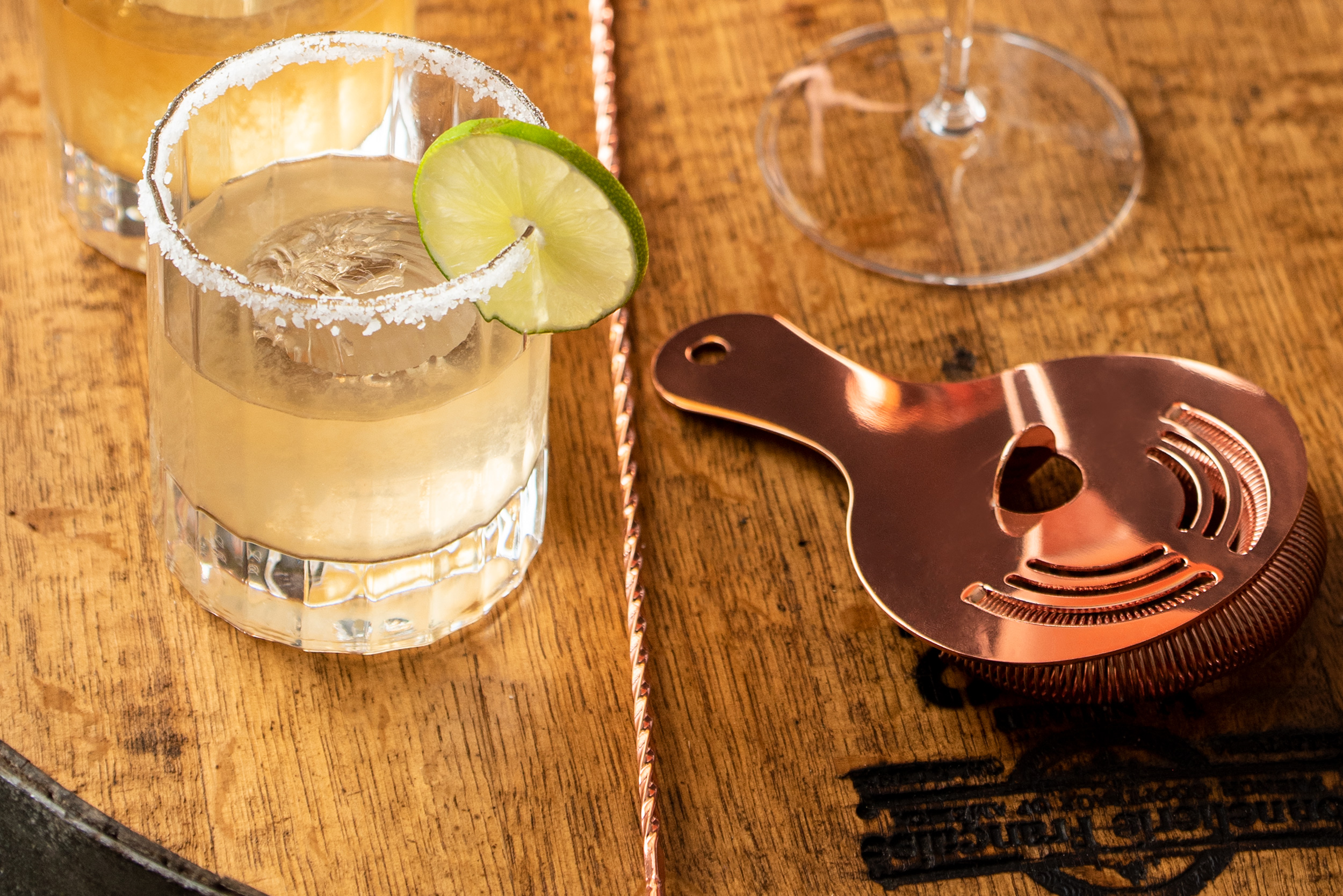 Essensia Margarita cocktail next to barware.