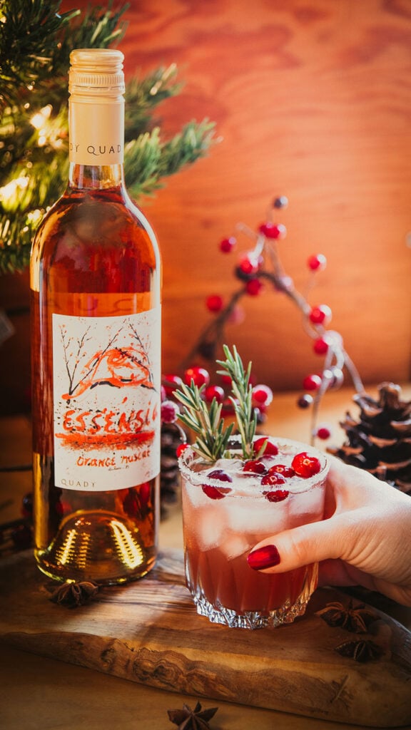Cranberry Orange Margarita made with Essensia Orange Muscat and garnished with fresh cranberries and sprigs of rosemary