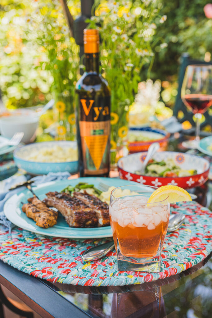 Lemon Tea Crush Iced Tea Cocktail with a plate of ribs and a bottle of Vya Vermouth