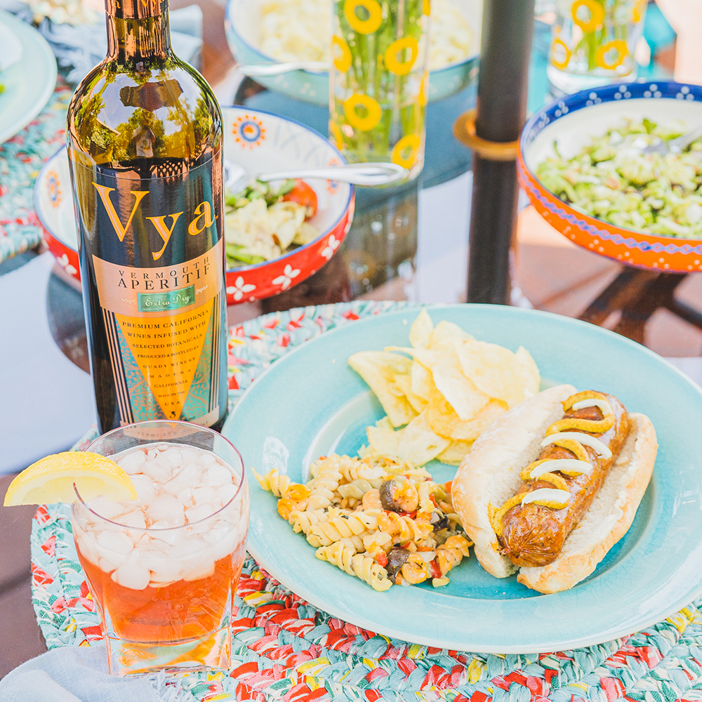 Iced Tea Cocktail with Vya Extra Dry Vermouth and a plate with a brat, chips and pasta salad