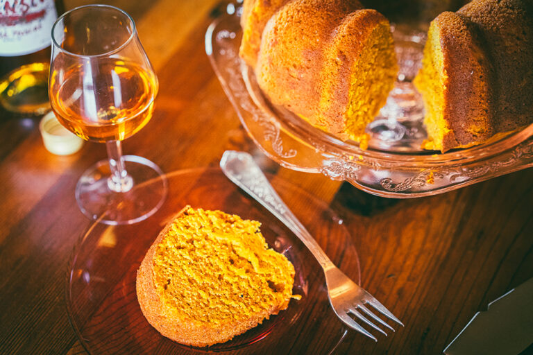 A slice of pumpkin pound cake with a glass of Essensia Orange Muscat